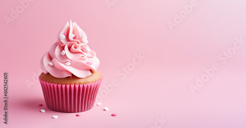 Cupcake with dragee on pink background with copy space