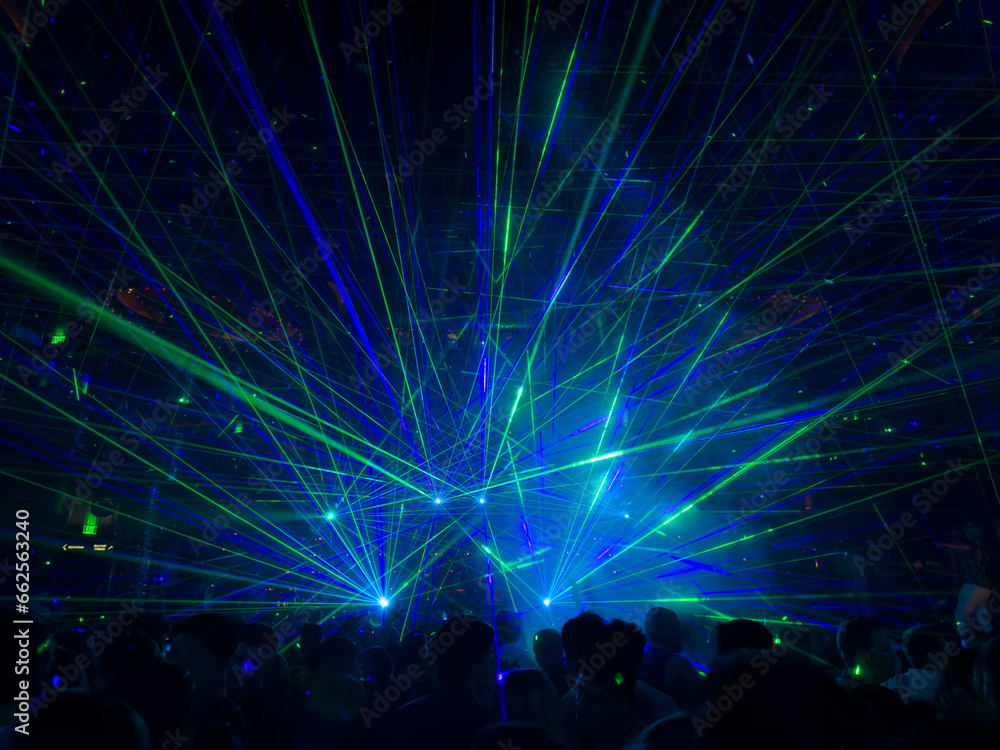 A view of a live show using green and blue colored lasers.