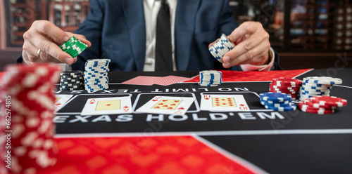 man wear suit playing poker at casino table, winning Royal Flush at casino
