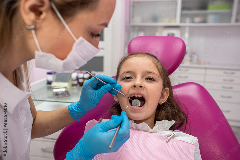 child sitting on couch looking scared with a drill in the hands of female dentist in clinic. child sitting on couch looking scared with a drill in the hands of female dentist in clinic.