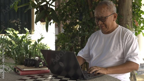 Senior man doing online work in the garden