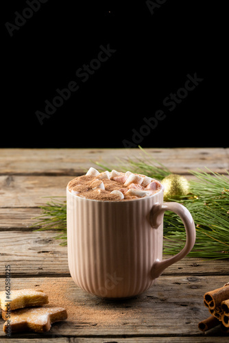 Vertical image of mug of chocolate with marshmallows and christmas decorations with copy space