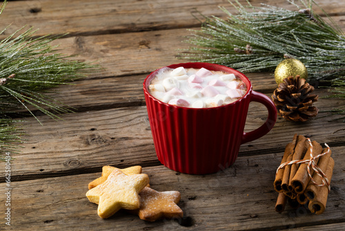 Red mug of chocolate and marshmallows and christmas decorations with copy space