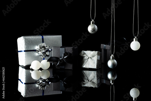 Silver christmas baubles and gifts with copy space on black background