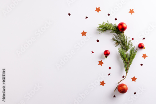Christmas stars, baubles decorations and fir tree branch with copy space on white background