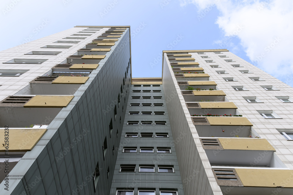 The gray white front of a high-rise apartment building with blue sky in the city of berlin, germany The gray white front of a high-rise apartment building with blue sky in the city of berlin, germany