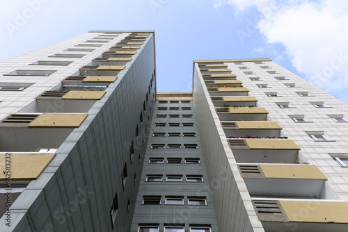 The gray white front of a high-rise apartment building with blue sky in the city of berlin, germany