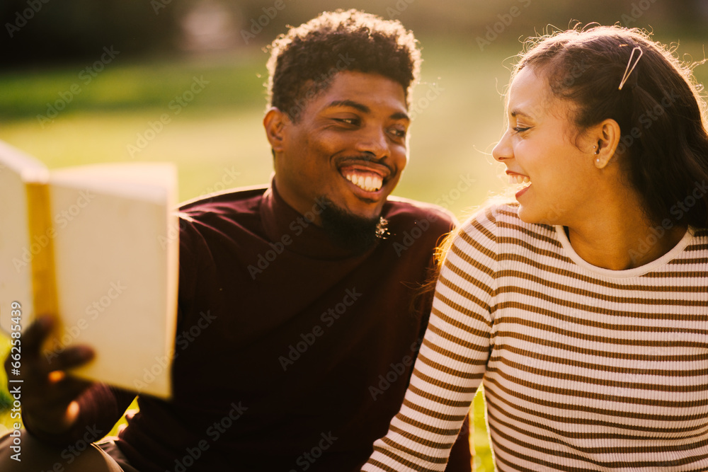 Young couple enjoying a park on a sunny day and reading a book Young couple enjoying a park on a sunny day and reading a book