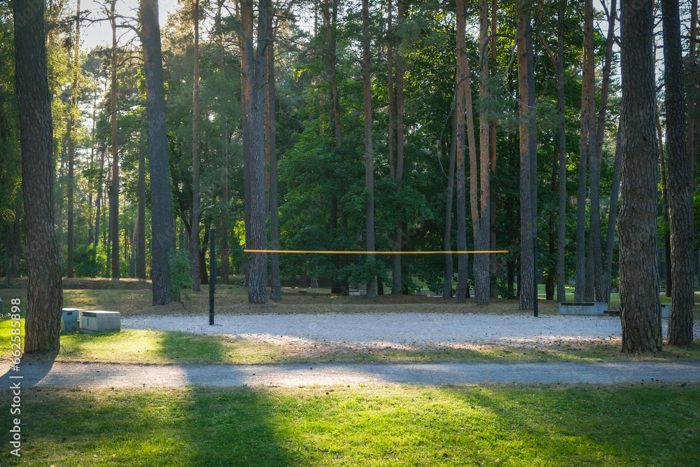Obraz premium Empty sand volleyball court in public city park. Volleyball court with net in sunny day