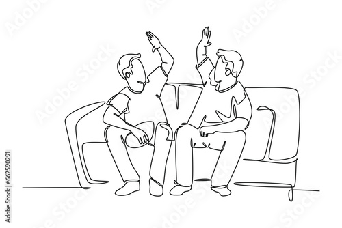 Single one line drawing fans siting on sofa watching their favorite American football club playing the match on television. Fans club concept. Continuous line draw design graphic vector illustration