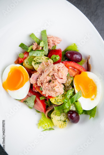 salad with soft-boiled egg, tuna, green onions, boiled potatoes, top view