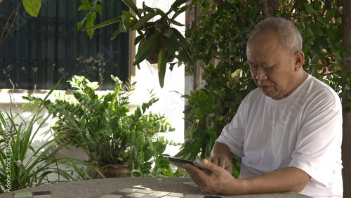 Senior man playing on laptop in the garden