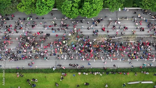 Start line of marathon with people gathering on street during running event, top down photo