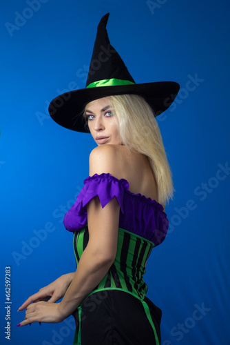 Blonde woman in black witch hat wearing costume for Halloween