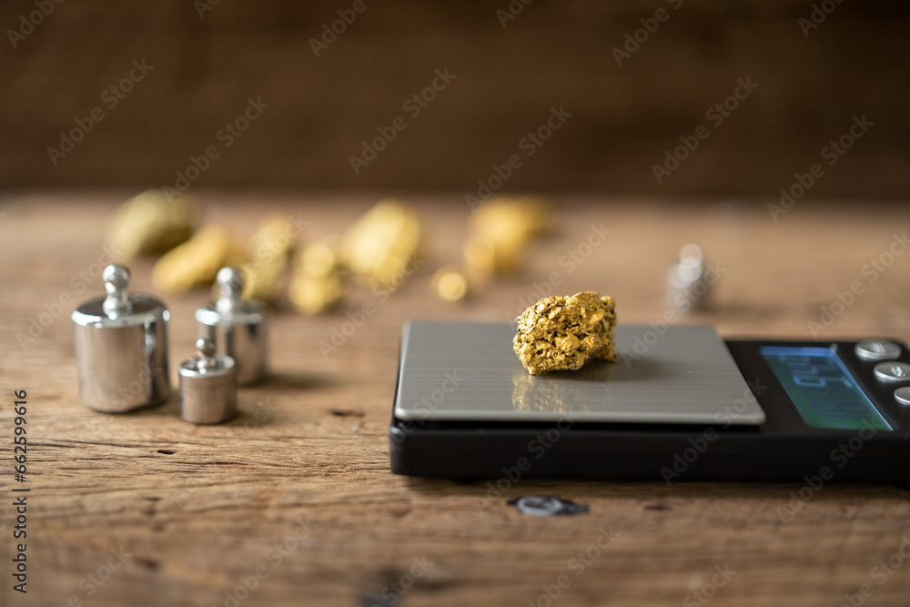 pure gold ore from a mine is placed on a weighing scale for evaluation. - obrazy, fototapety, plakaty 