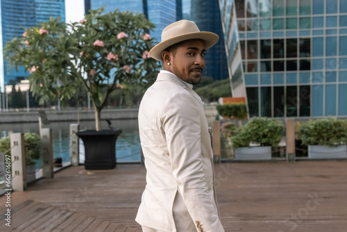 Canvas Print An attractive groom at an international wedding in a light suit with dark skin against the backdrop of the modern city of Singapore