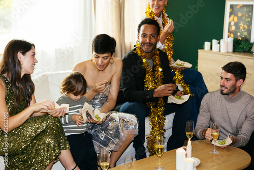 Multi-generation family having food at new year party in living room at home photo