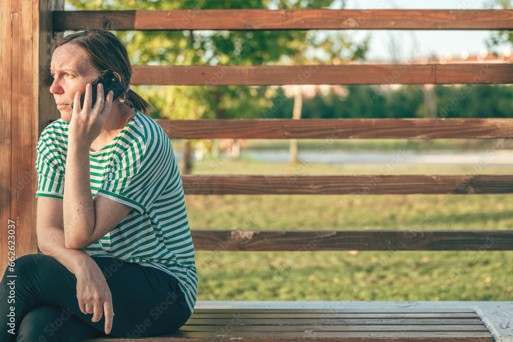 Woman calling on mobile phone with no answer outdoor in public park Woman calling on mobile phone with no answer outdoor in public park