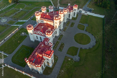 aerial view on overlooking restoration of the historic castle or palace in forest near lake or river photo