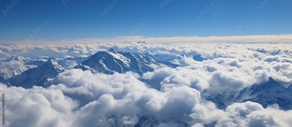 A shot of mountains above a cloudy sky in a clear blue sky, atmospheric ambience.