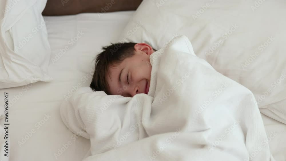 portrait of cute kid boy lying on bed under blanket,talking on old phone,relax playing with sheet.sunshine from window,smiling child trying to sleep,take a nap daytime.4k portrait of cute kid boy lying on bed under blanket,talking on old phone,relax playing with sheet.sunshine from window,smiling child trying to sleep,take a nap daytime.4k
