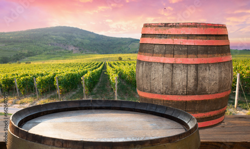 Red wine bottle and wine glass on wodden barrel. Beautiful Tuscany background. High quality photo