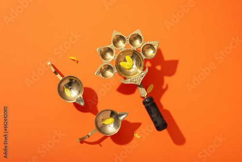 Copper oriental utensils on orange background, top view