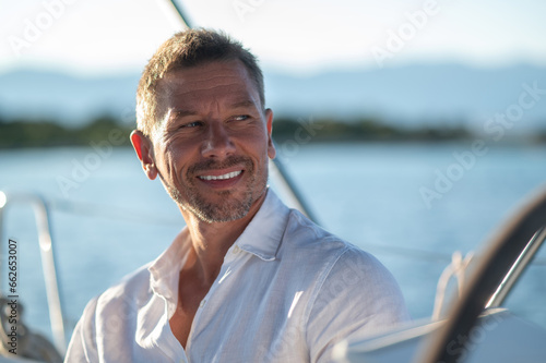 Smiling man traveling on a yacht and looking contented