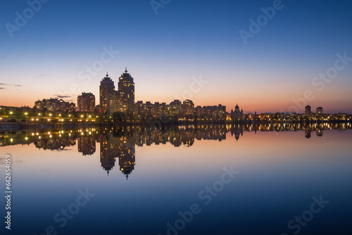 Water reflection of buildings and sunset sky in the city