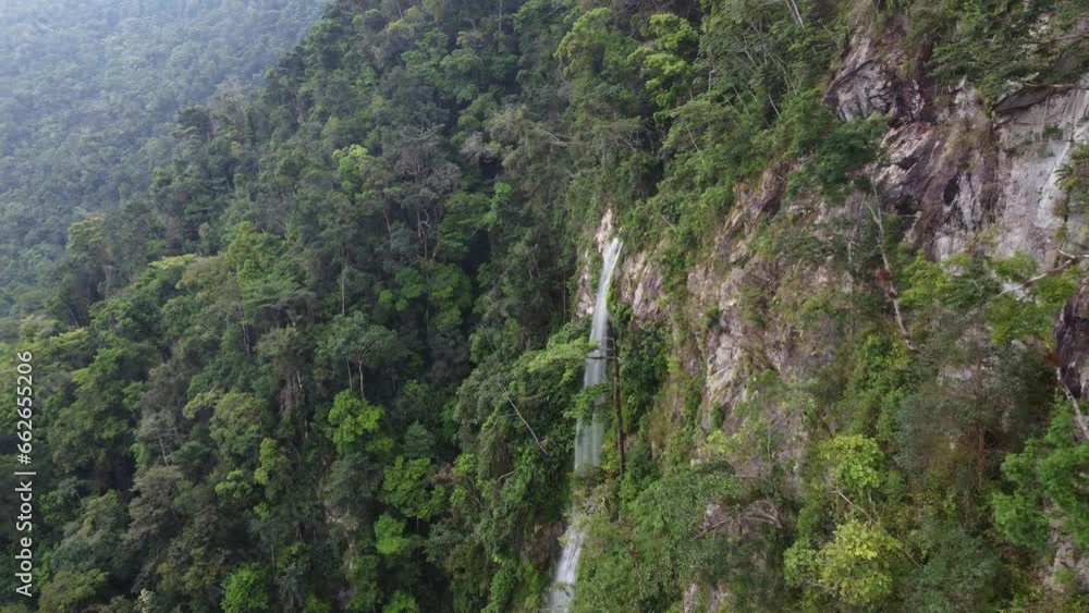 Cliff aerial flies to wispy jungle waterfall in Honduras mountains Cliff aerial flies to wispy jungle waterfall in Honduras mountains