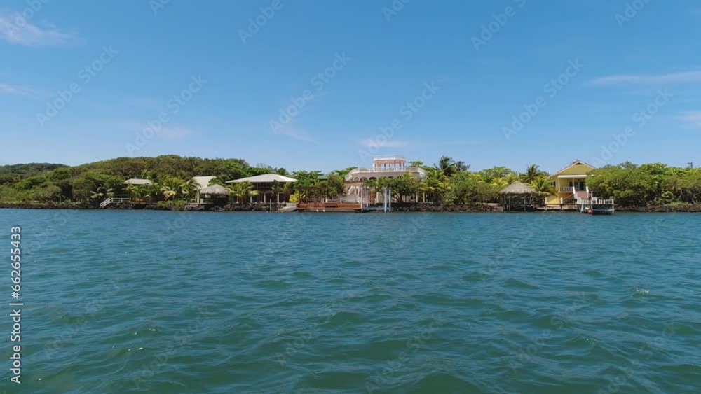 From a boat, affluent waterfront homes on coast of Roatan, Honduras From a boat, affluent waterfront homes on coast of Roatan, Honduras