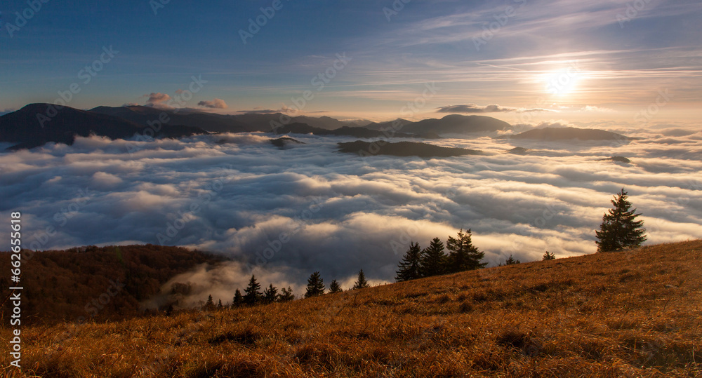 Sunset hidden behind clouds and fog over hills, bright yellow sun on colorful cloudscape, blue violet orange sky. Sunset hidden behind clouds and fog over hills, bright yellow sun on colorful cloudscape, blue violet orange sky.