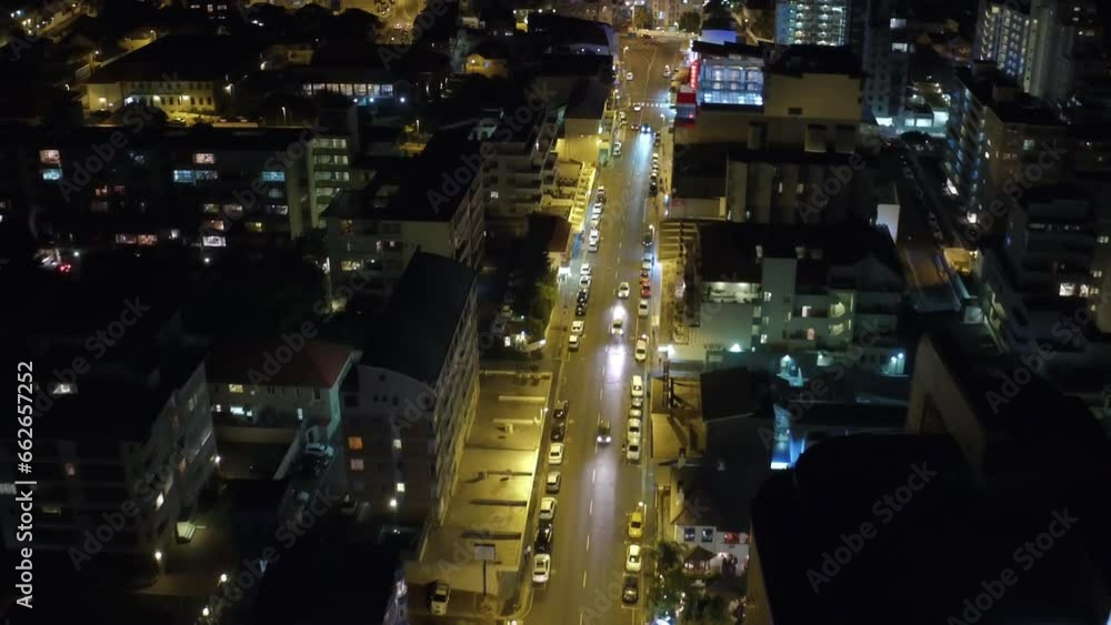 City, commercial and night with lights from a drone pov for travel, transportation or commute with office buildings. Traffic, street and skyscraper architecture with cars driving in the evening City, commercial and night with lights from a drone pov for travel, transportation or commute with office buildings. Traffic, street and skyscraper architecture with cars driving in the evening