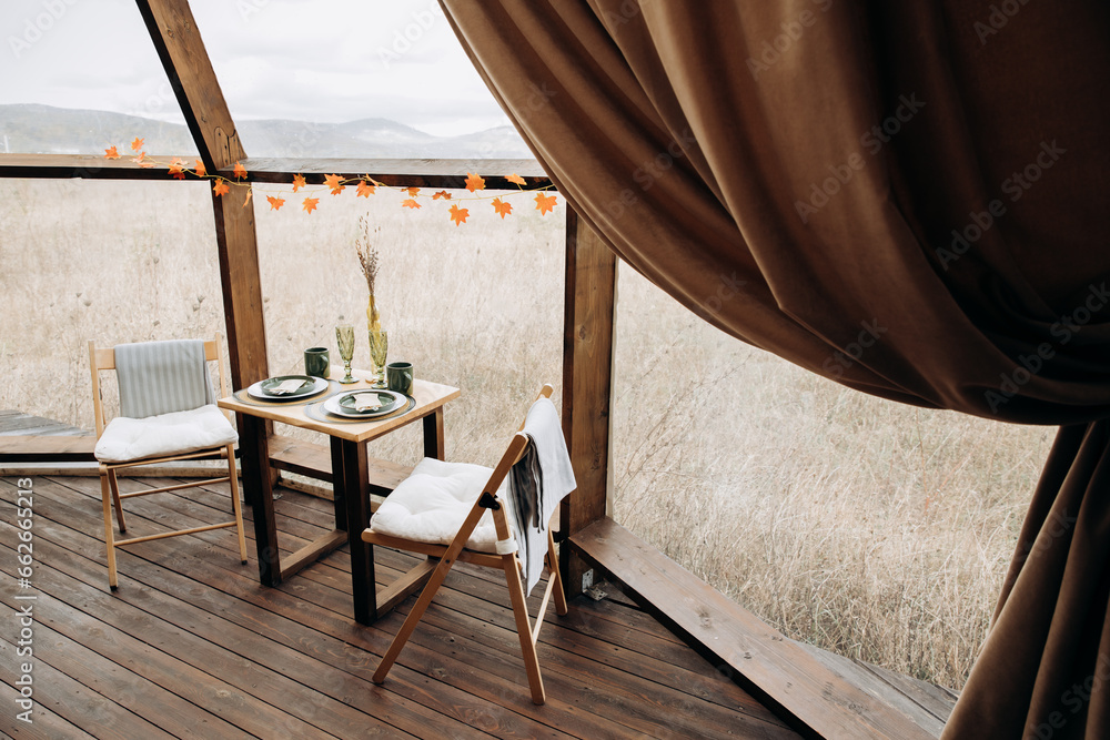 Table setting for breakfast, lunch or dinner. Table for two indoors with panoramic windows amidst nature. Catering, cafe, restaurant Table setting for breakfast, lunch or dinner. Table for two indoors with panoramic windows amidst nature. Catering, cafe, restaurant