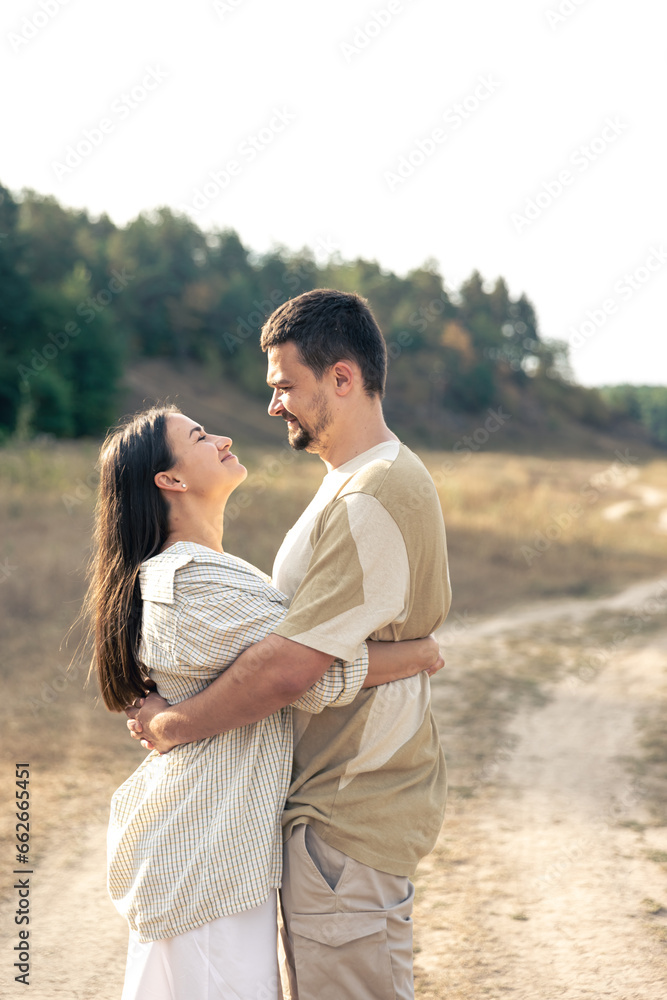 Mature man and woman in the field are hugging.