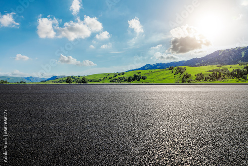 Road and green mountain landscape under blue sky © ABCDstock