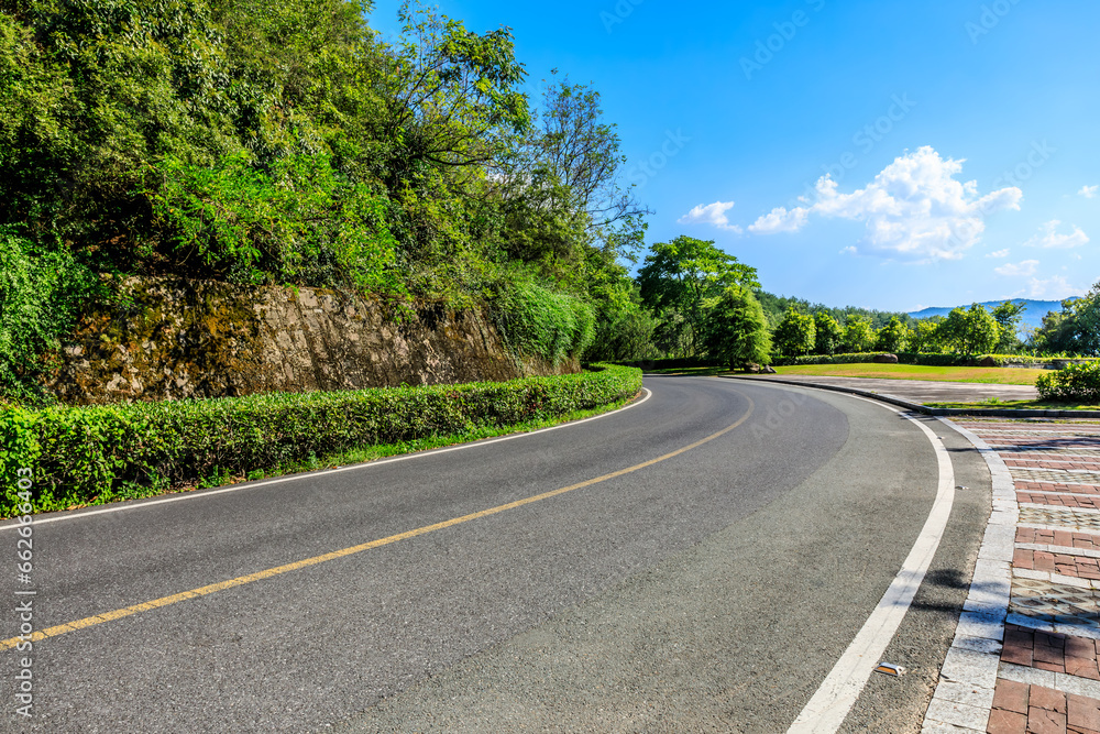 Fototapeta premium Highway and green mountain landscape under blue sky