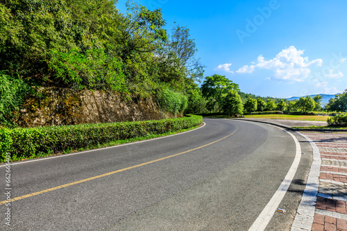 Highway and green mountain landscape under blue sky