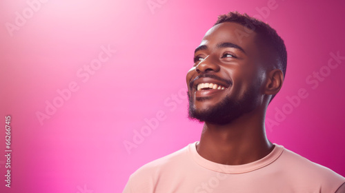 Portrait of a smiling young african american man on pink neon light background with copyspace