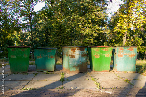 Old green metal trash cans in the park. Square metal outdoor trash containers
