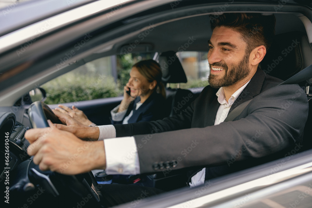 Two positive business colleagues in suit carpooling journey into work together