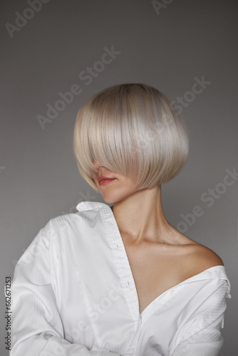 Blonde woman with short dyed hair, short haircut. Hair root care, woman in shirt fashion portrait