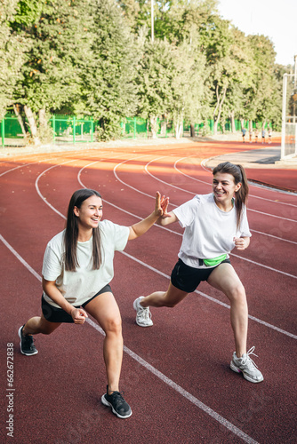 Attractive young women in sportswear jogging in the stadium.