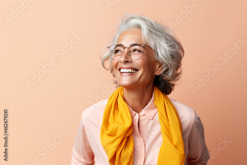 Portrait of attractive elderly happy laughing woman with gray hair wearing glasses over beige background. AI generated