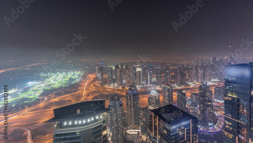 Panorama of Dubai Marina with JLT skyscrapers and golf course night timelapse  Dubai  United Arab Emirates.