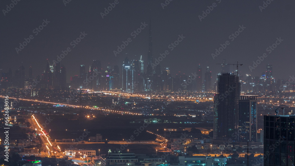 Dubai Downtown skyline row of skyscrapers with tallset tower aerial all night timelapse. UAE