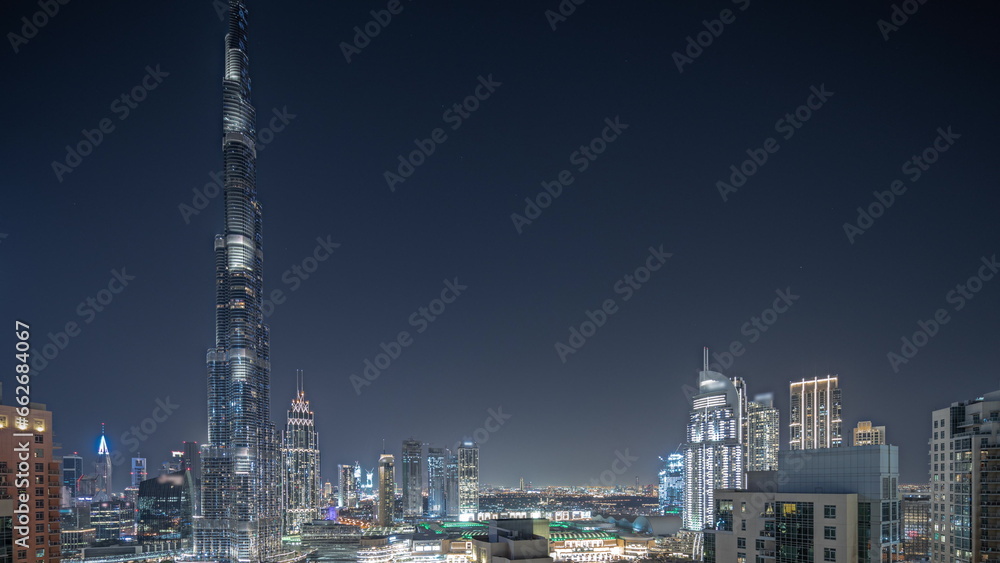 Fototapeta premium Panorama showing aerial cityscape night timelapse with illuminated architecture of Dubai downtown.