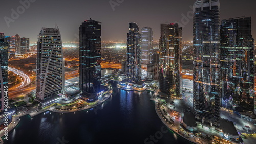 Tall residential buildings at JLT aerial night timelapse, part of the Dubai multi commodities centre mixed-use district.