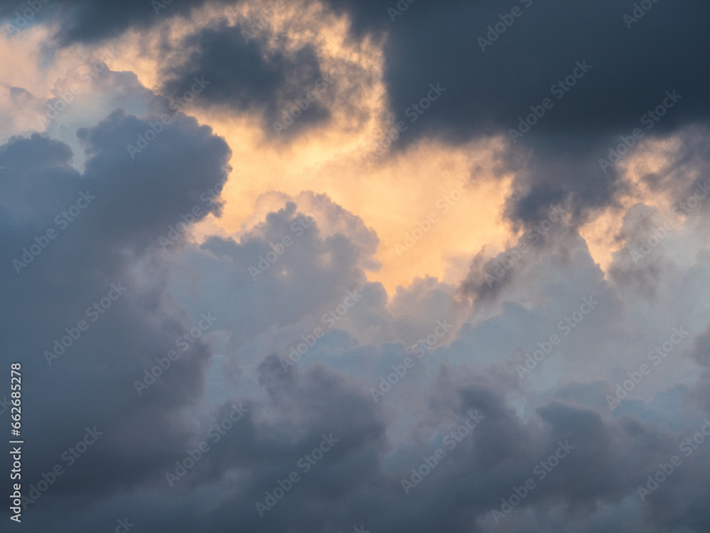 Blue sky after rain,. Beautiful Cumulus clouds flying across the sky, sunset rays, pink and orange shades in the clouds, deep blue sky