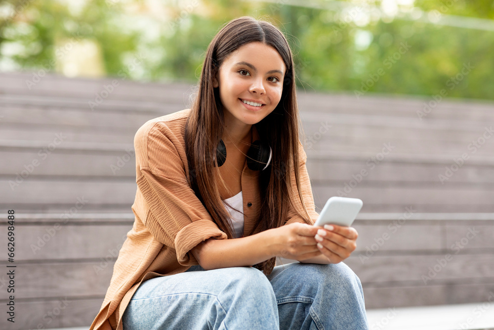 Student happy woman scrolling on smartphone, busy campus scene Student happy woman scrolling on smartphone, busy campus scene